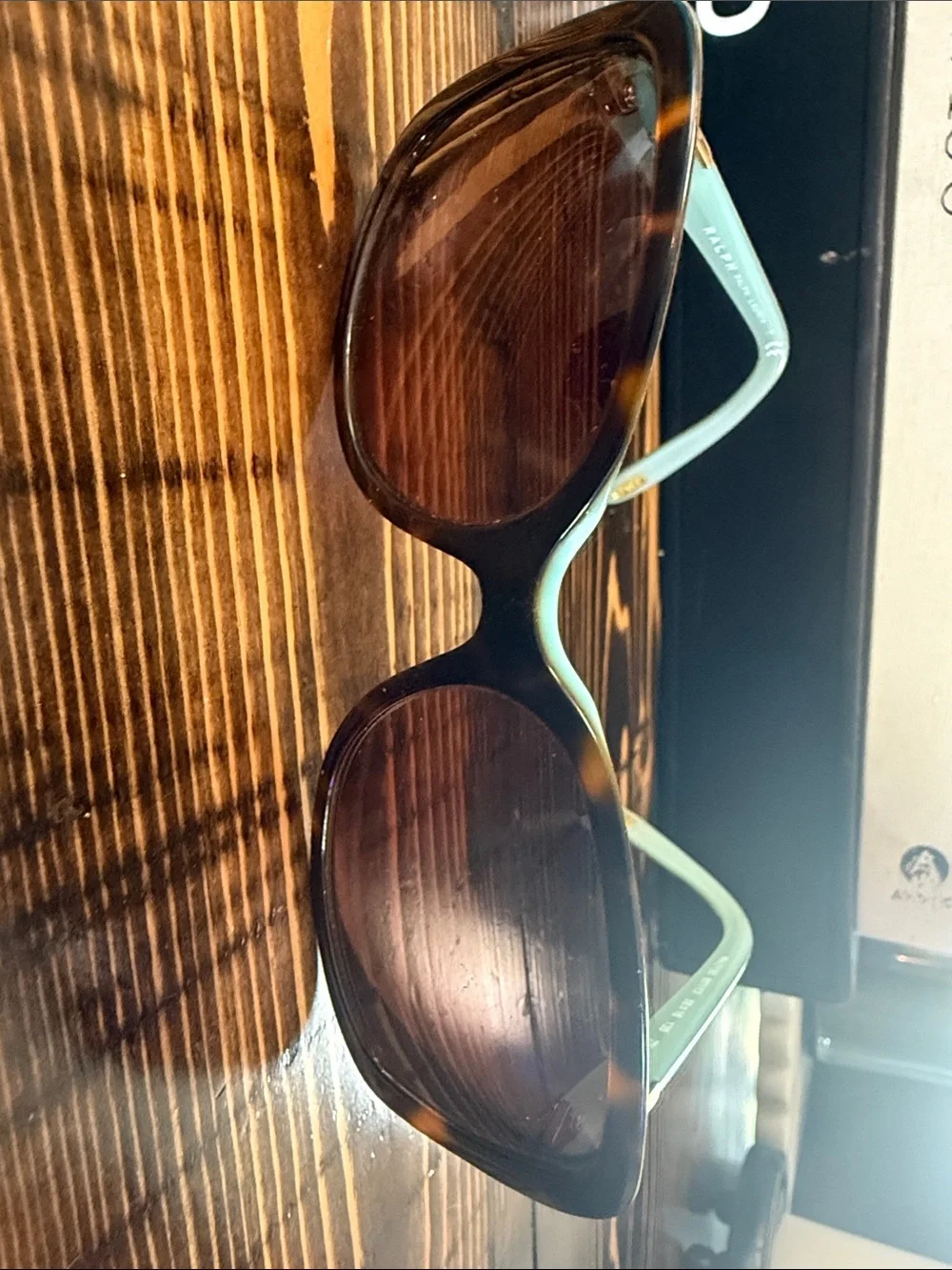 Ralph Lauren sunglasses feature a teal frame and tortoise-shell temples. Frames